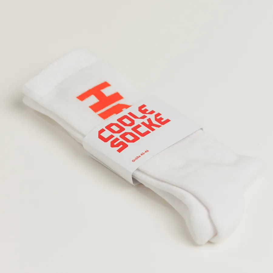 Weiße Socke der HFT Stuttgart mit rotem Logo und Banderole Coole Socke